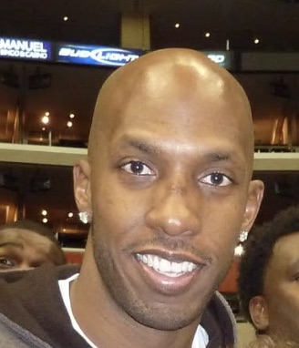 Chauncey Billups smiling courtside at an arena