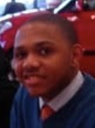 Eric Gordon wearing a dress shirt, tie and blue sweater