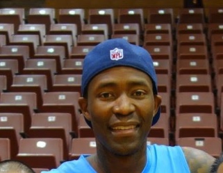 Jamal Crawford smiling in a backwards cap at an arena